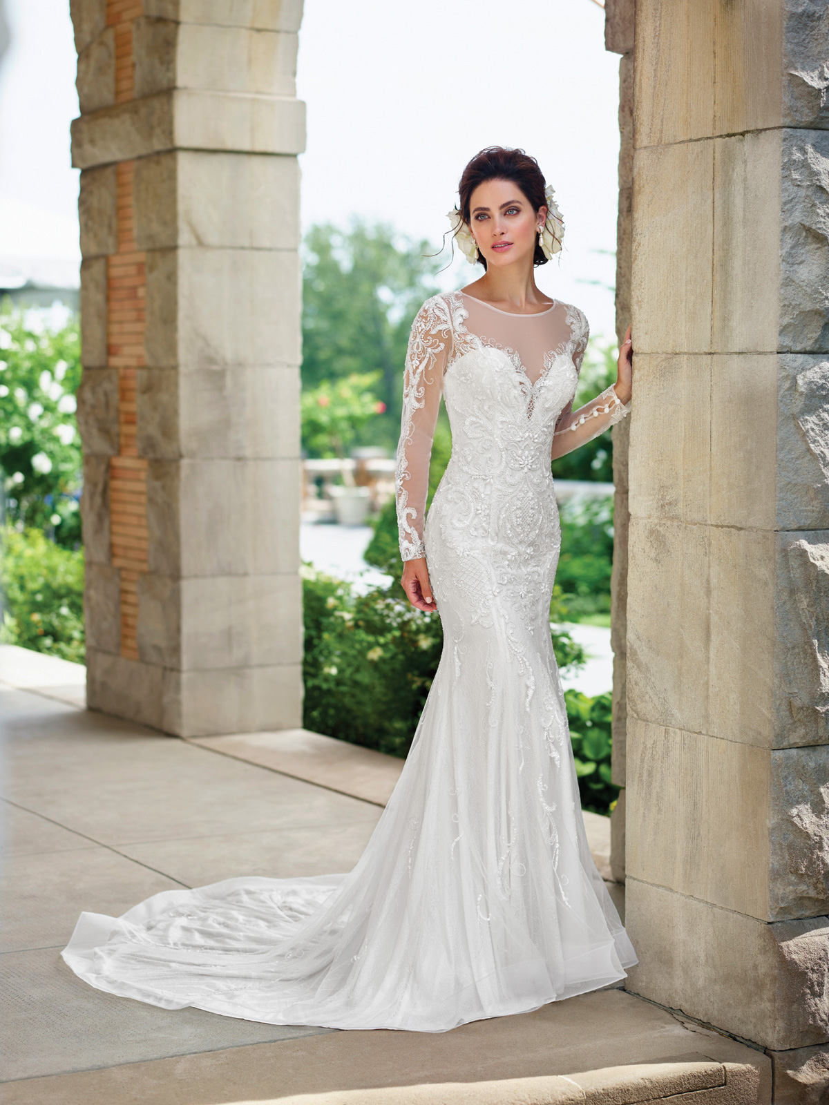 Vestido de Noiva decote ilusion com mangas e colo na transparncia, todo confeccionado em tule e trabalhado com aplicaes em renda rebordada em pedrarias, cauda curta.