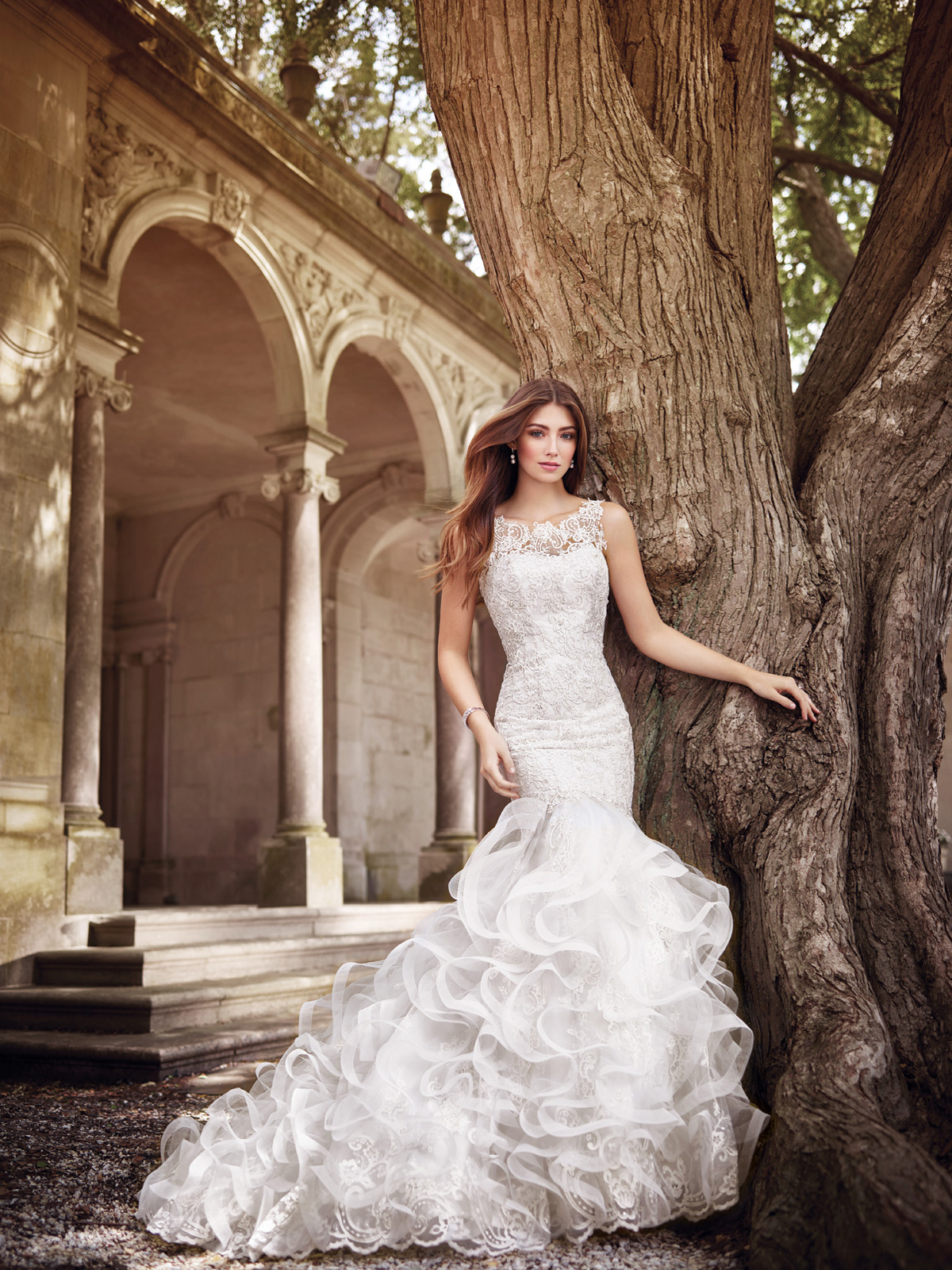 Vestido de Noiva decote canoa com transparncia no colo e costas, confeccionado em renda francesa rebordada em pedrarias e corte de saia sereia toda trabalhada em camadas de organza com apliques de renda aleatrios.