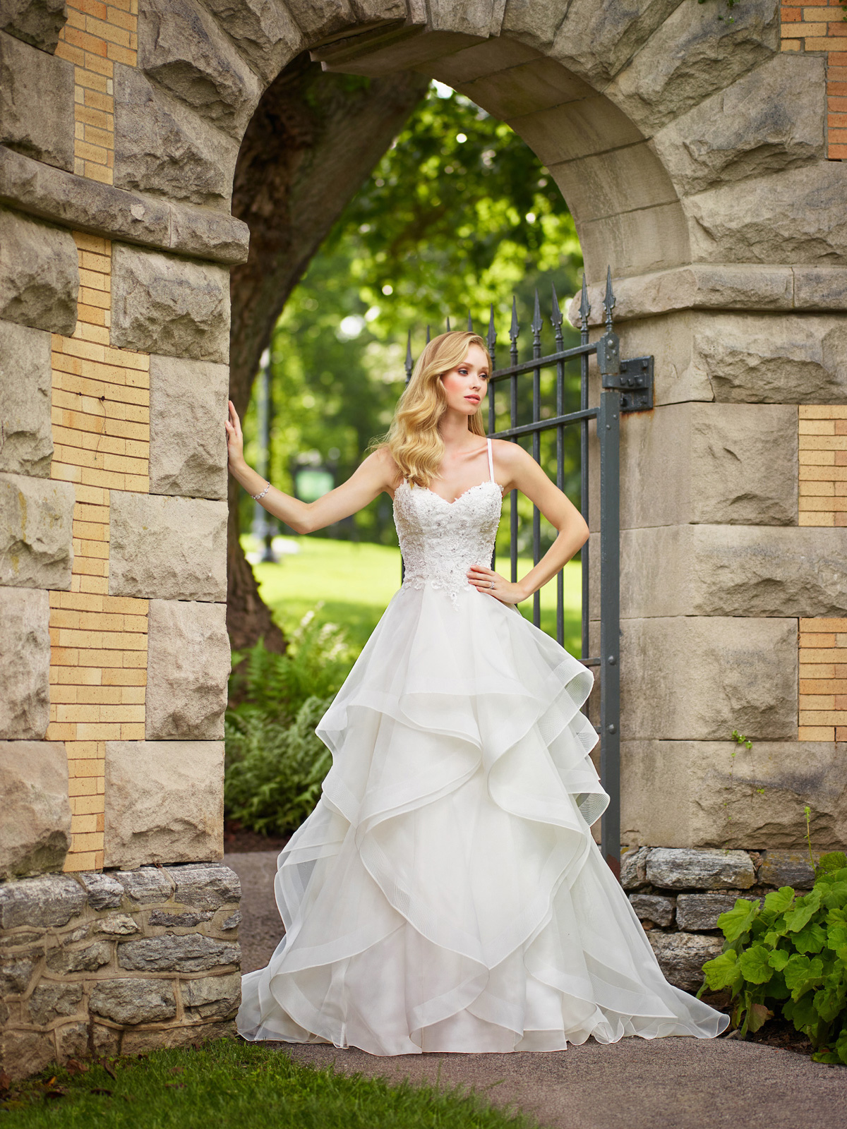 Faa uma entrada triunfal com esse vestido de noiva que tem um corpete em renda rebordada em pedrarias bem acinturado, seu decote princesa e alas delicadas valorizam o colo e sua saia ampla em camadas irregulares de organza, completam esse modelo.