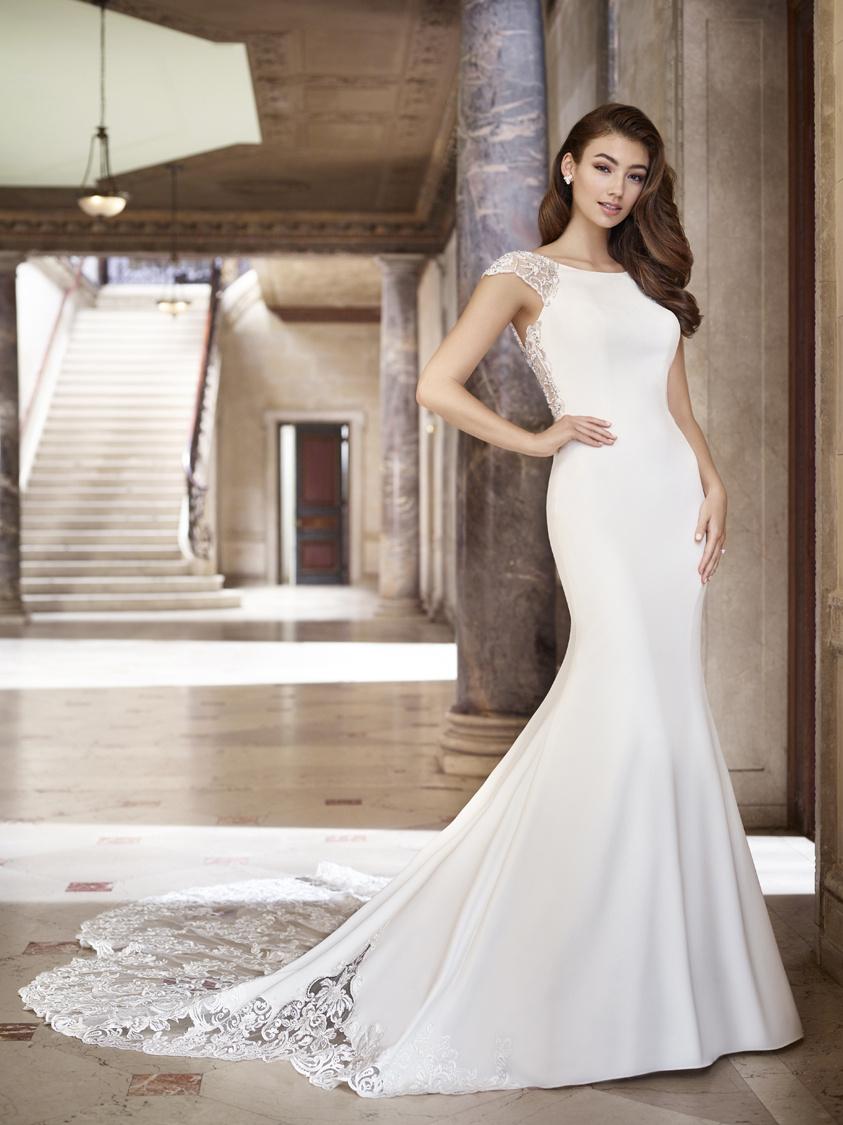 Um vestido de noiva em crepe aparentemente simples, porm imponente, ele apresenta um decote canoa clssico, deslumbrante transparncia nas mangas e costas, este vestido brilhante tambm inclui uma arrebatadora cauda com detalhe de transparncia da renda em seu barrado que o tornam to especial.