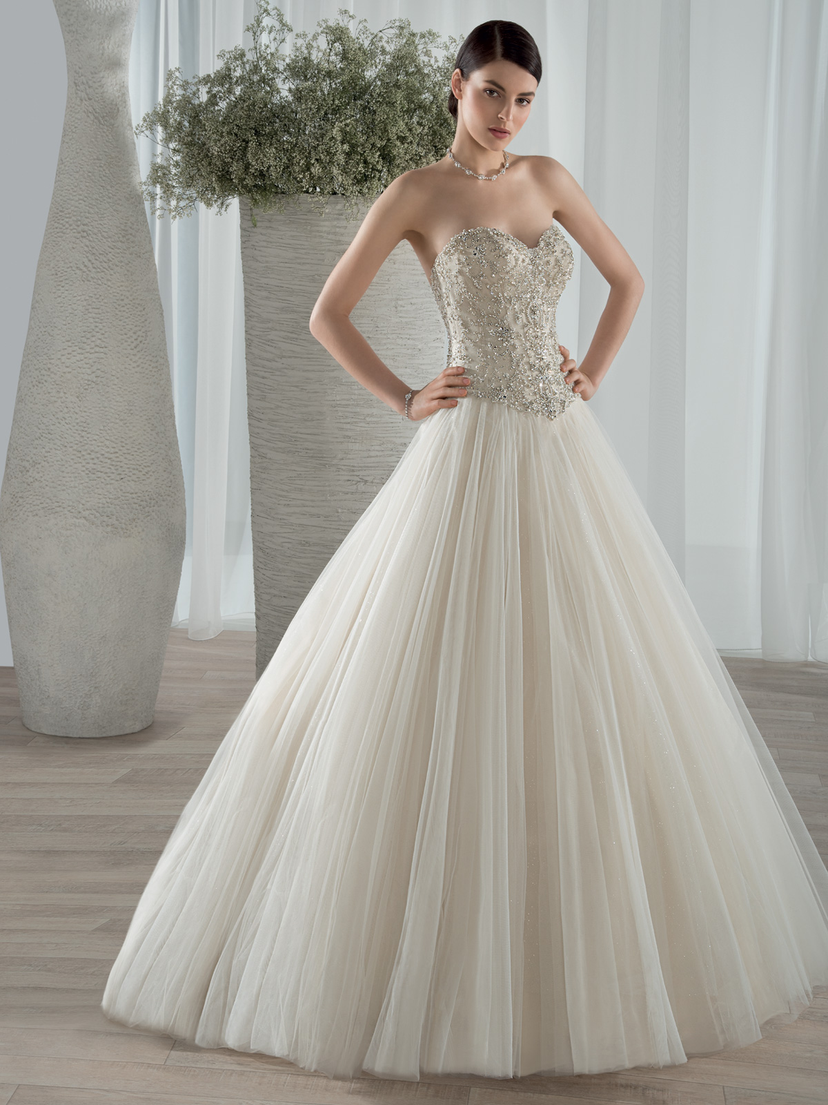 Vestido de Noiva tomara que caia com corpo acinturado todo bordado em pedrarias e cristais, saia com corte franzido em camadas de tule francs liso, leve cauda.